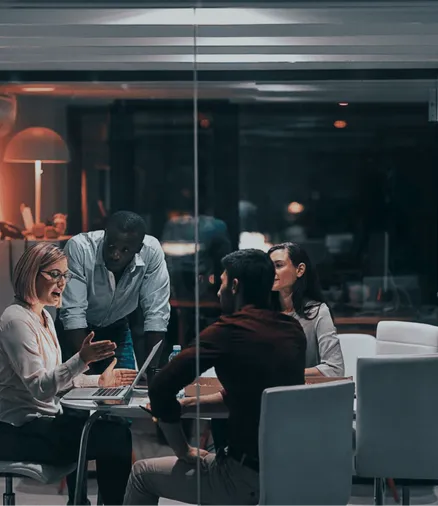 A team discussing a product at a table in a dim office